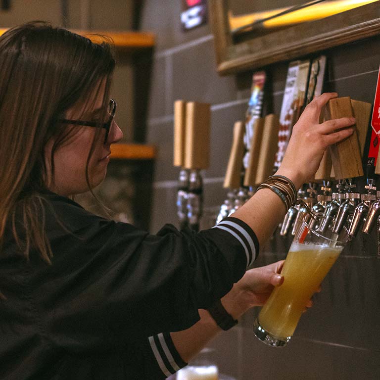 Woman pouring beer from tap